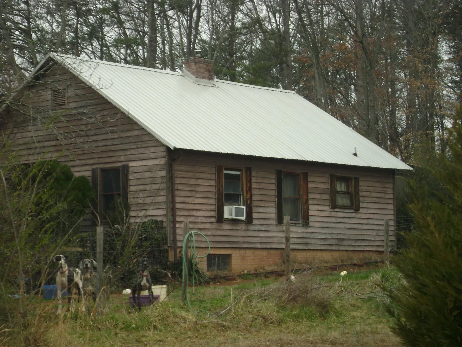 White metal roof on an old wood sided farmhouse, from a Metal Roof Installation job in Spencer